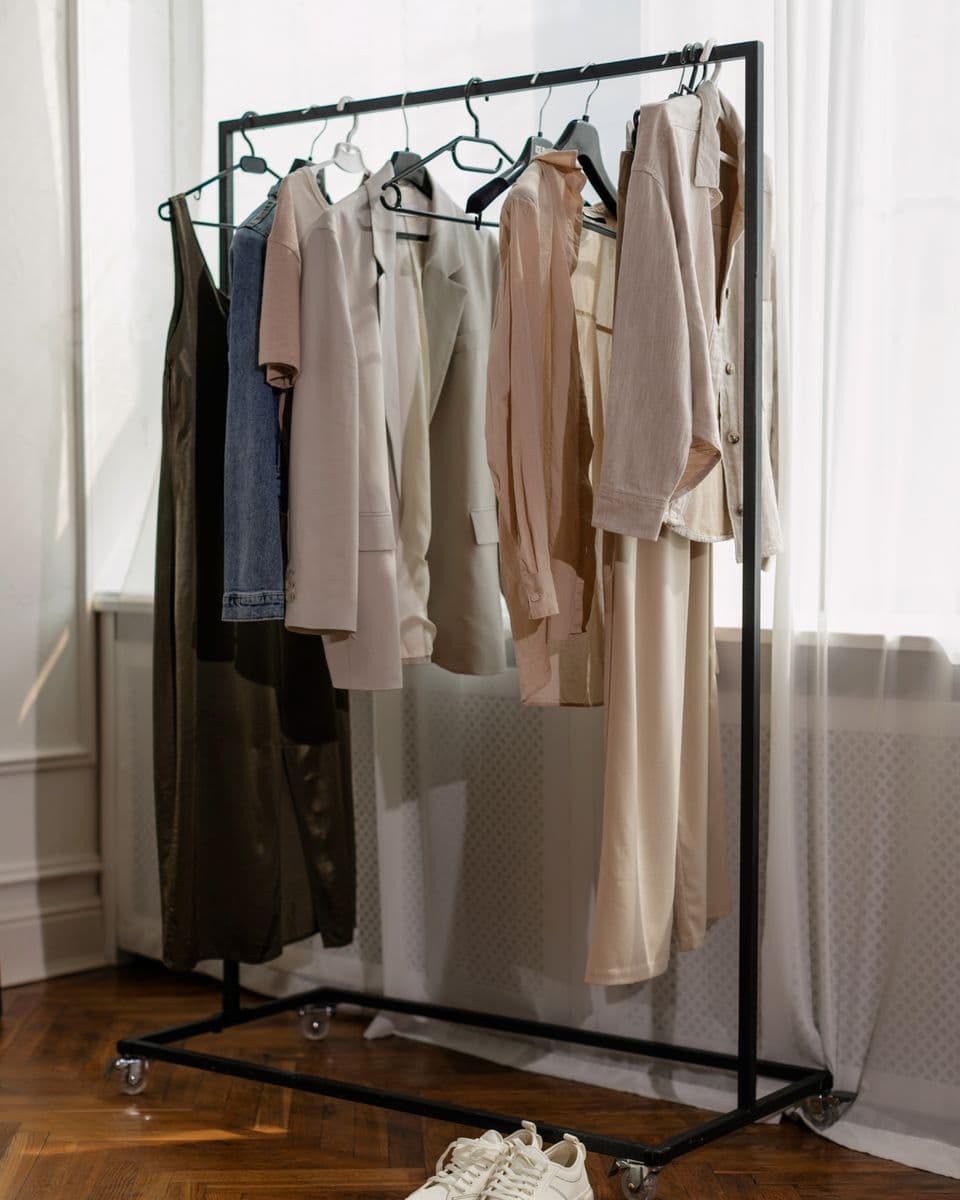 A minimalist clothing rack of neutral-toned garments, evenly spaced and organized